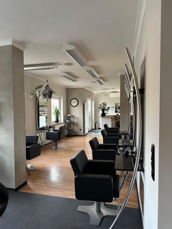 Blick durch den Salon mit Frisierplätzen, Trockenhaube und Empfang im Hintergrund